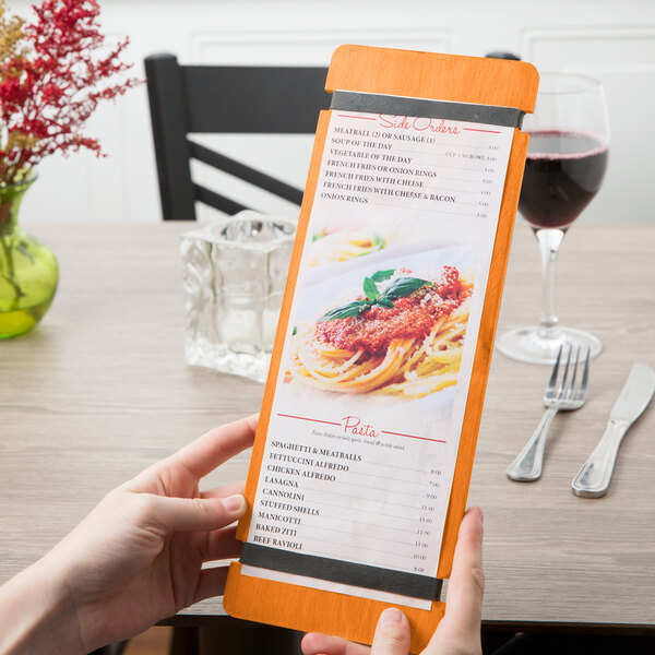 A hand holding a Menu Solutions wood menu board with rubber band straps.