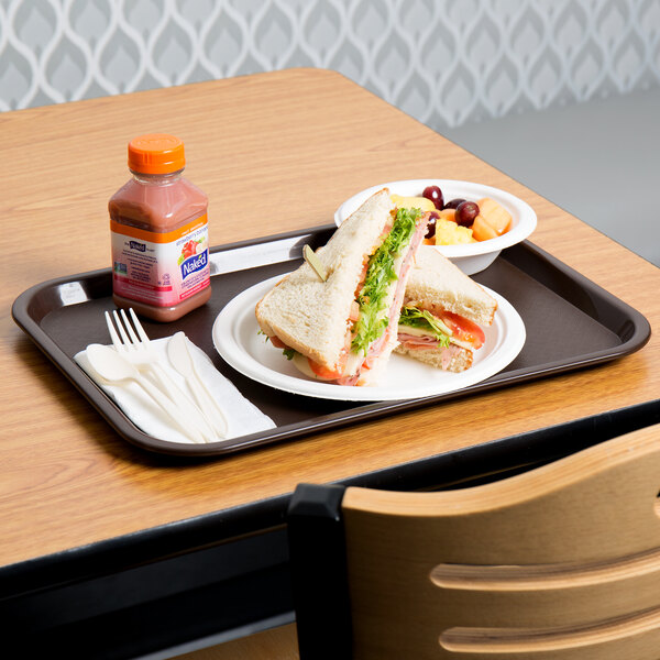 A Choice plastic fast food tray with a sandwich, fruit, and a bottle of liquid.
