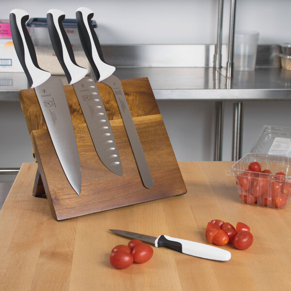 A Mercer Culinary Millennia® knife set on a wooden block with white and black handles.