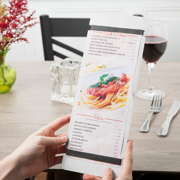 A hand holding a customizable wood menu board with rubber band straps.