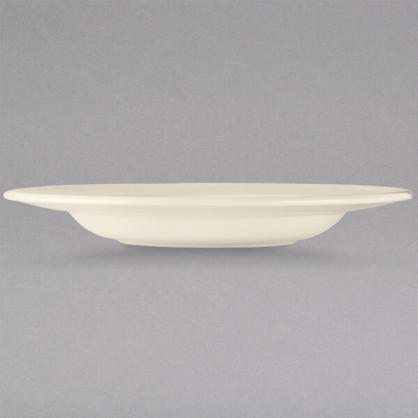 A Libbey cream white china pasta bowl with a black rim.