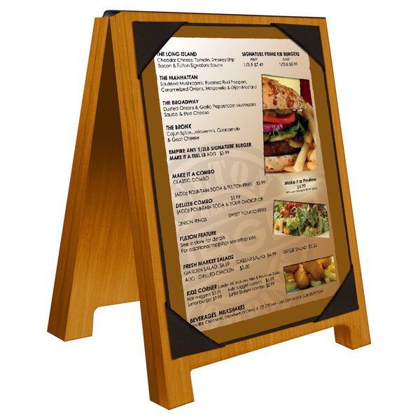 A Menu Solutions country oak wood menu board tent with picture corners on a table with a menu on it.