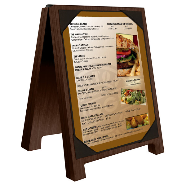 A Menu Solutions walnut wood sandwich menu board with picture corners on a table with a menu.