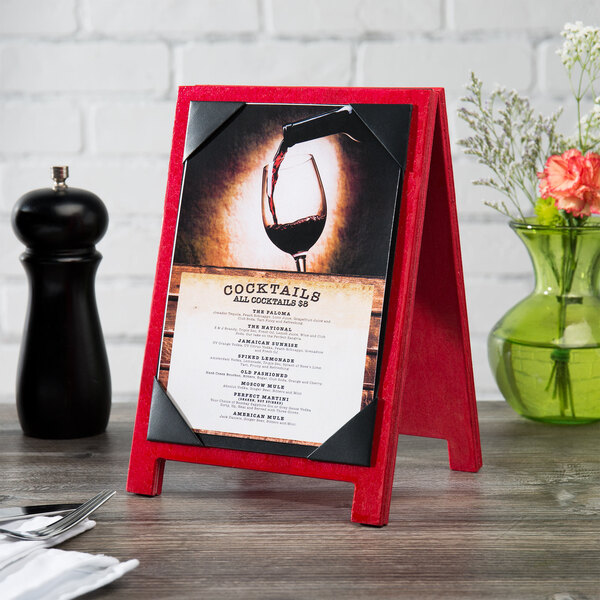 A wood table with a Menu Solutions Berry Wood Sandwich Menu Board Tent with a picture in it.