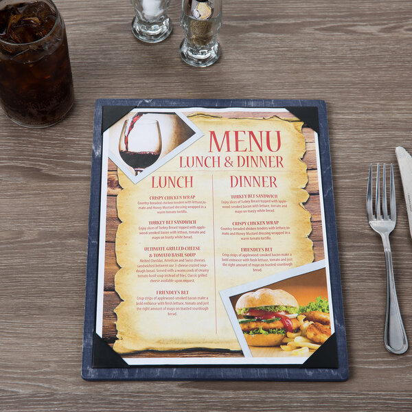 A Menu Solutions wood menu board on a table with a glass of brown liquid with ice and a menu with a picture of food.