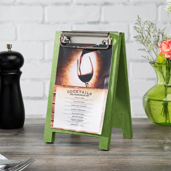 A lime wood Menu Solutions sandwich menu board tent on a table with a menu on it.