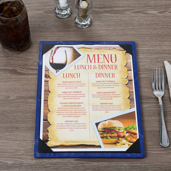 A Menu Solutions wood menu board on a table with a burger and fries and a glass of brown liquid.