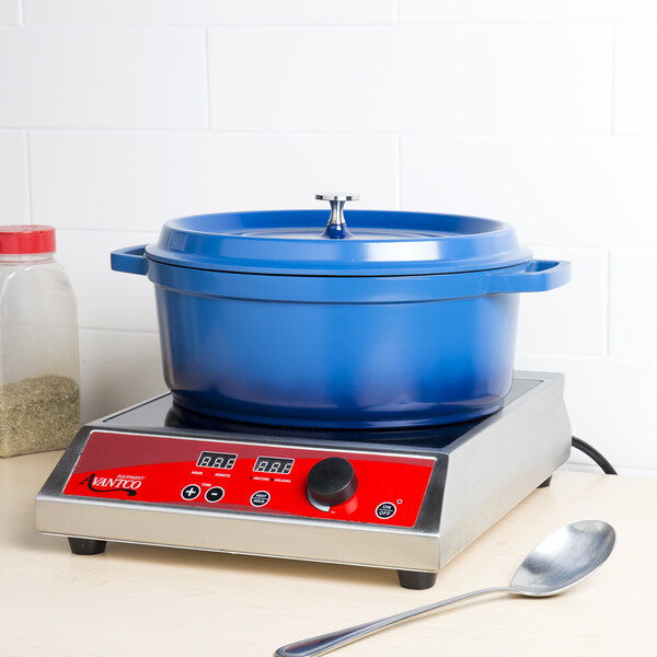 A cobalt blue oval Dutch oven with a lid on a counter.