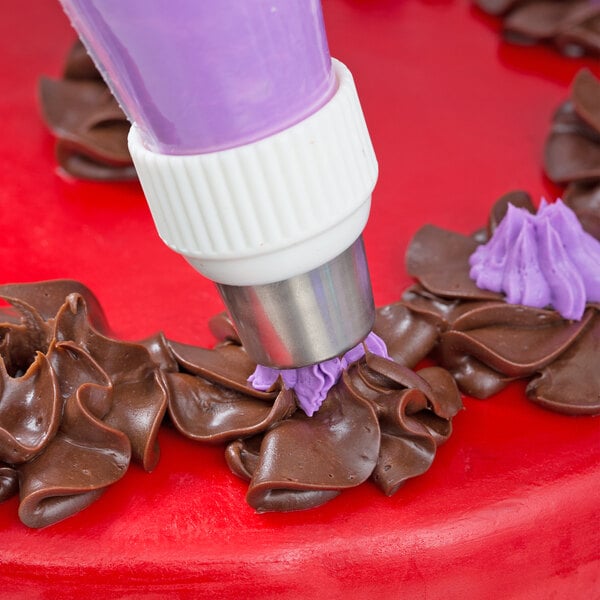 A purple and white Ateco Russian piping tip being used to decorate a cake.