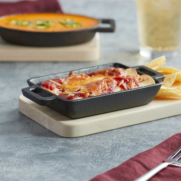 A Valor pre-seasoned cast iron mini casserole dish with food in it on a table.