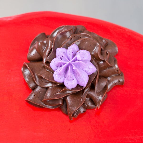 A chocolate cake with purple and chocolate frosting piped with an Ateco Russian piping tip.