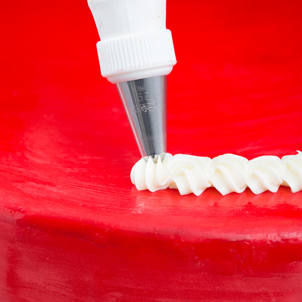 A red cake with white frosting piped using an Ateco closed star piping tip.