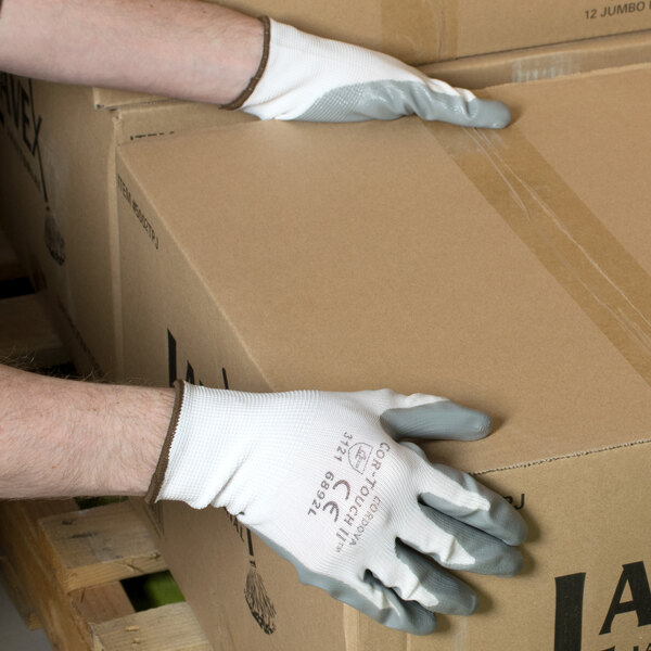 A person wearing Cordova Cor-Touch II gloves holding a box.