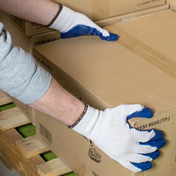 A person wearing Cordova blue latex palm coated work gloves holding a box.