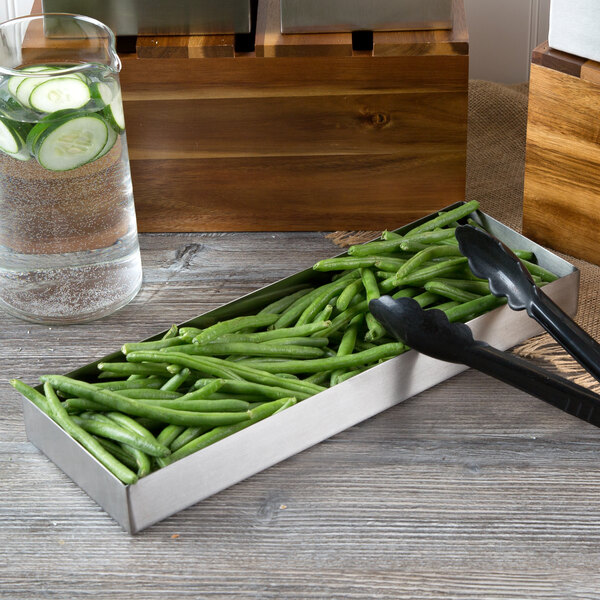 A Tablecraft rectangular stainless steel bowl filled with green beans with tongs.