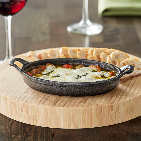 A Valor mini cast iron casserole dish filled with food and cheese.