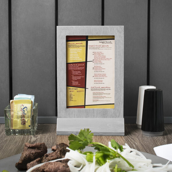 Menu Solutions white wash wood menu tent on a table with food.