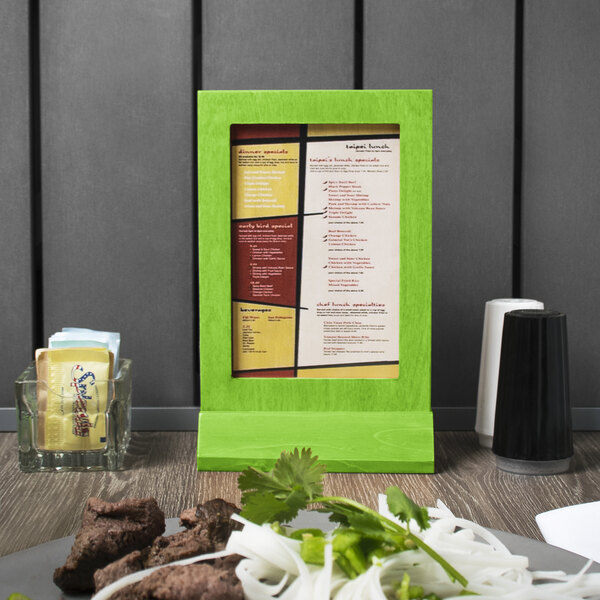 A Menu Solutions lime wood framed menu tent on a table.