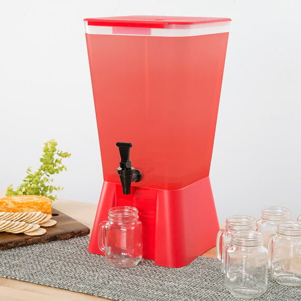 A red Choice plastic beverage dispenser with a tap on a table with glass jars.