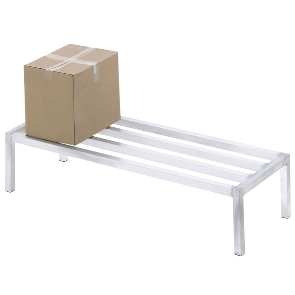A cardboard box sits on a Channel aluminum dunnage rack.