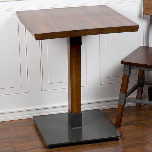 A Lancaster Table & Seating wooden dining table with a metal base.