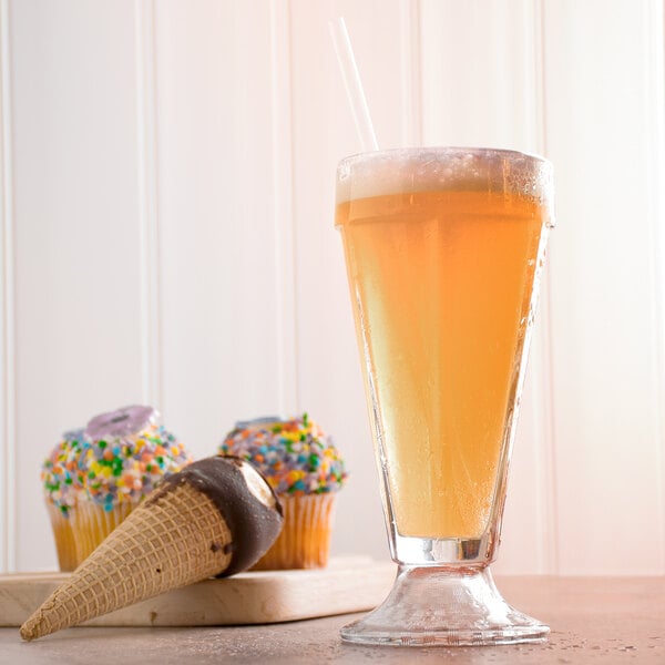 A close-up of a glass of Narvon Old Fashioned Cream Soda with ice cream and a cupcake.