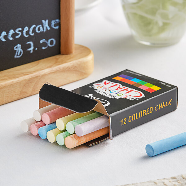 A box of Choice Assorted Colored Chalk next to a chalkboard.