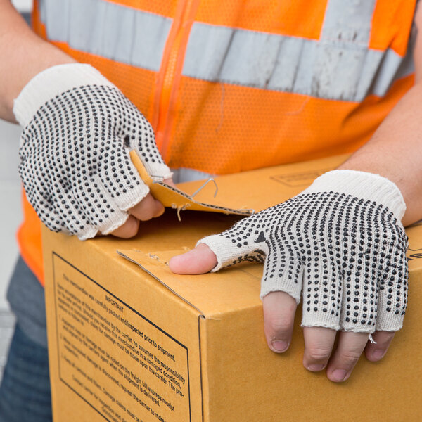 A person wearing Cordova fingerless gloves opening a box.