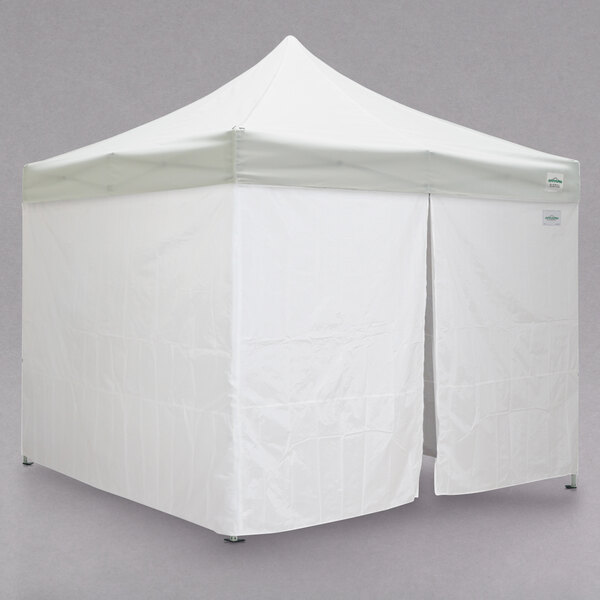 A Caravan Canopy white tent with two doors open.