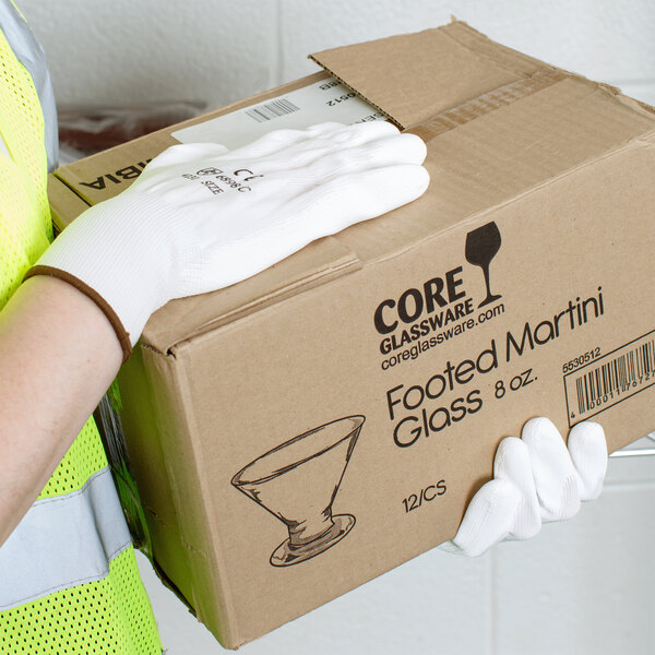 A person wearing Cordova white gloves with white polyurethane palms holding a box.