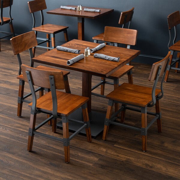 A Lancaster Table & Seating wooden table and chairs in a restaurant dining area.