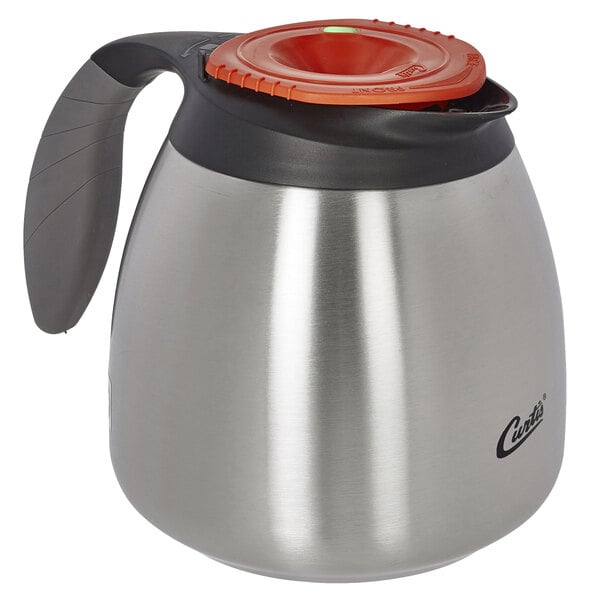 A Curtis stainless steel coffee carafe with a red lid.