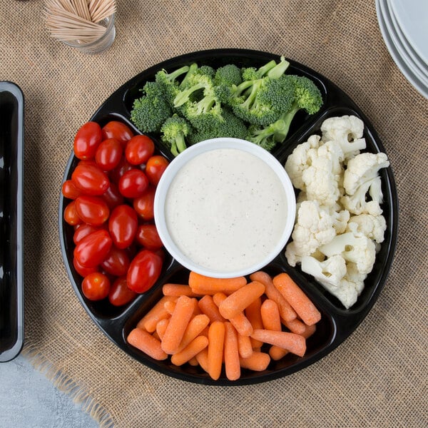 A black Fineline 5-compartment tray with baby carrots, broccoli, and dip on it.