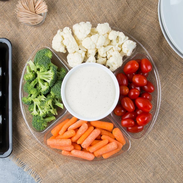 A Fineline clear plastic 5-compartment tray with baby carrots, broccoli, and dip on a counter.
