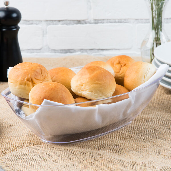 A bowl of bread rolls on a counter.
