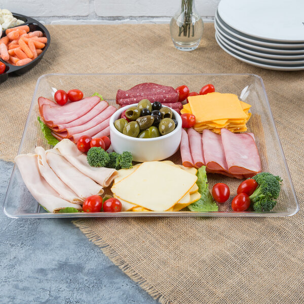 A Fineline clear plastic square catering tray with meat, cheese, and vegetables on it.