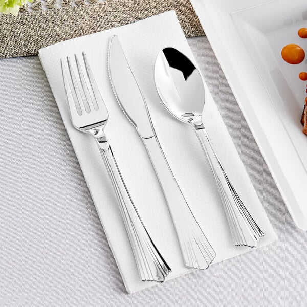 A Visions silver plastic fork and knife on a white napkin.