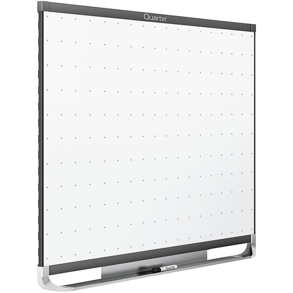 A Quartet Total Erase whiteboard with a grid on it and a black frame.