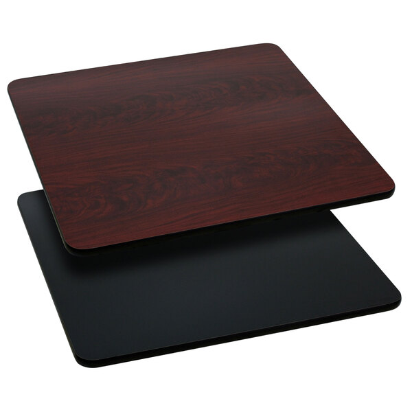 A close-up of a black and mahogany reversible square table top.