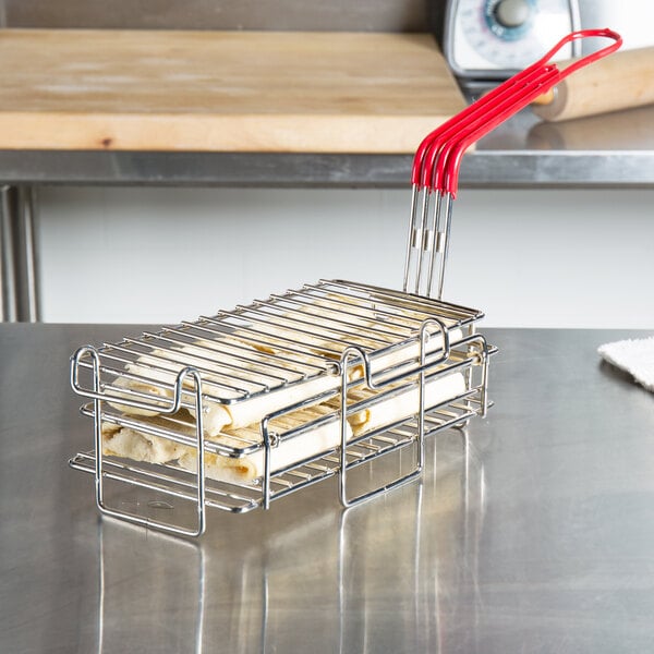 A Tablecraft burrito fryer basket filled with food on a metal rack.
