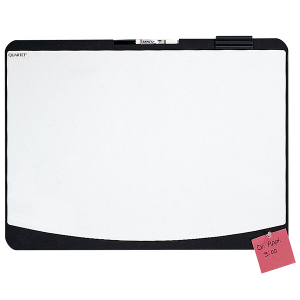A white Quartet melamine whiteboard with a black border with a sticky note on it.