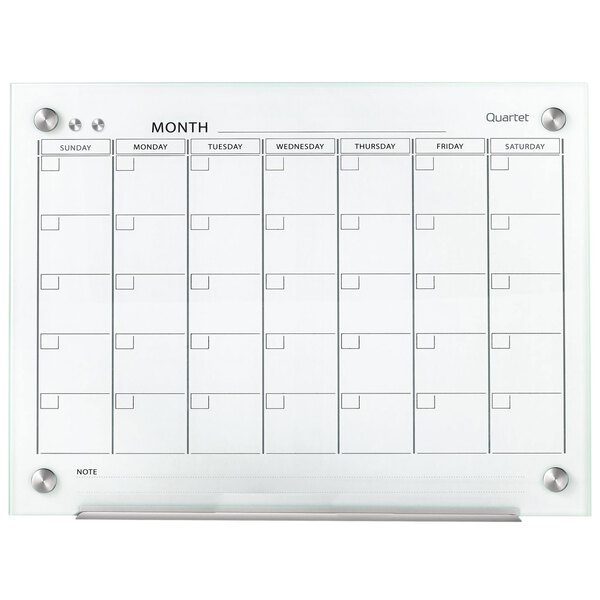 A Quartet glass calendar with a white background and metal markerboard.