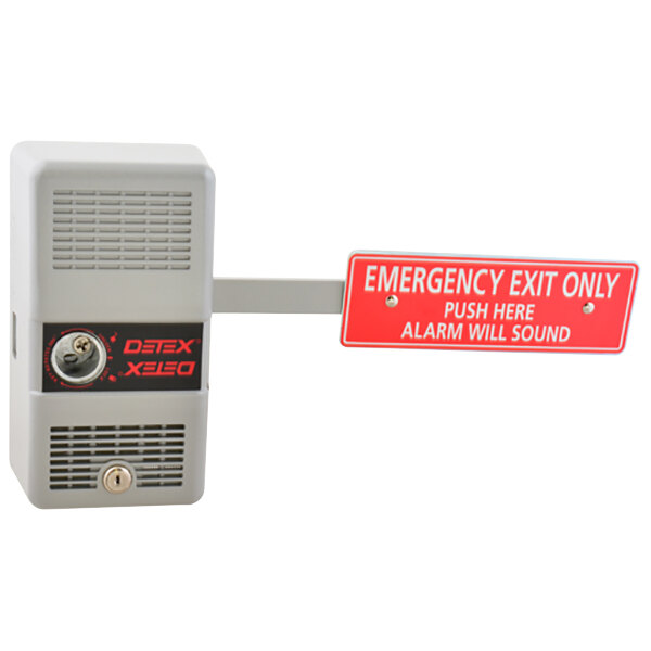 A close-up of a Detex emergency exit door alarm with a red sign and white text.