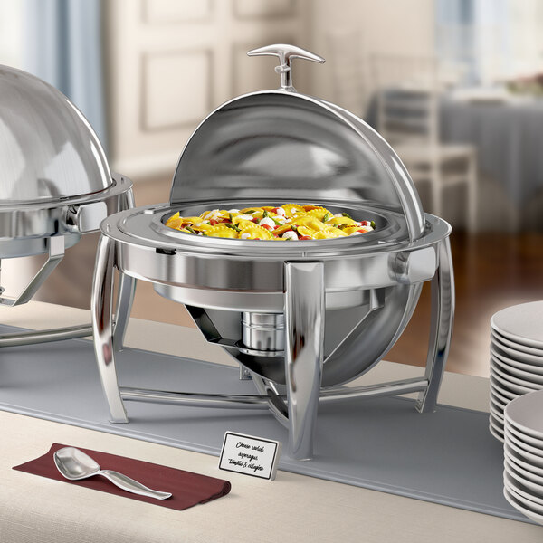 An Acopa stainless steel roll top chafing dish on a table with a plate and silverware.
