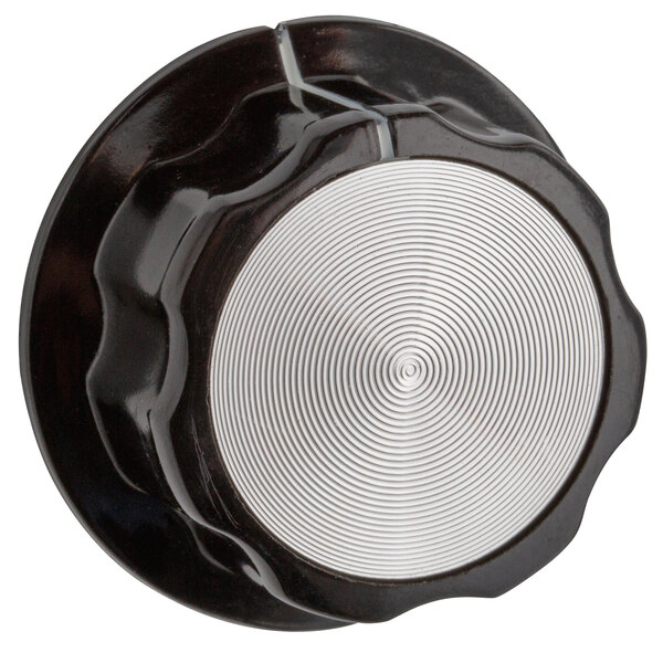 A black and silver knob with a white circular pattern.