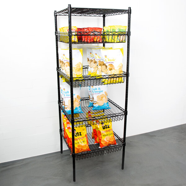 A black metal Regency wire shelving kit with 4 baskets and 1 shelf holding bags of chips.