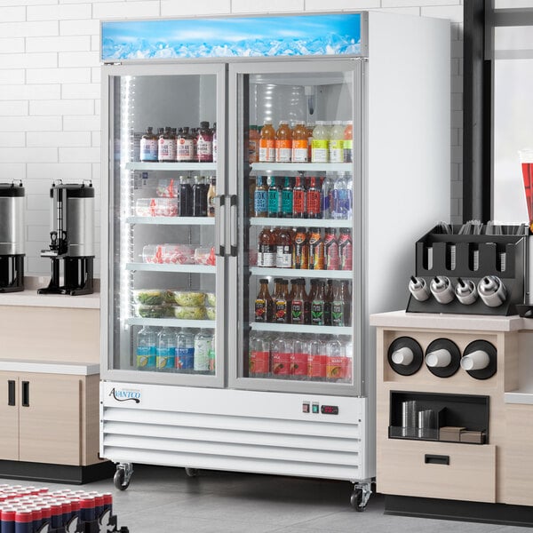 An Avantco white swing glass door merchandiser refrigerator with drinks on shelves.