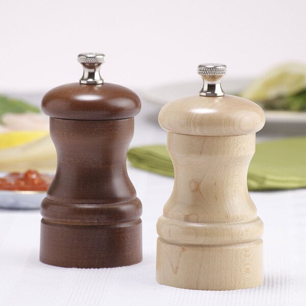 A wooden pepper mill and salt mill set on a table.