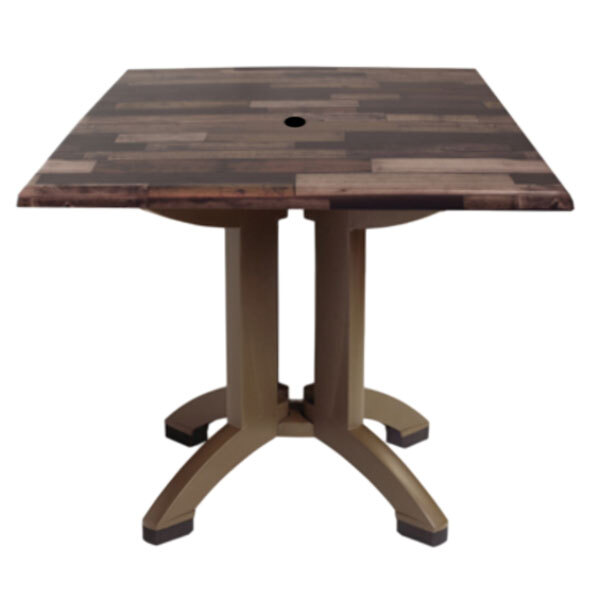 A Grosfillex outdoor table with a square wood top and umbrella hole.