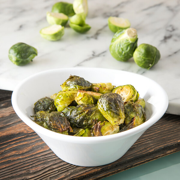 A white Carlisle melamine bowl filled with brussels sprouts.